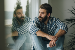 man with anxiety and stress looking out of the window